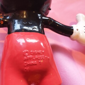 Peut inclure: Figurine vintage de Mickey Mouse, avec un corps noir brillant, un short rouge et des gants blancs. La figurine porte du texte au dos, dont les marques Disney et Applause. La figurine est pos&eacute;e avec les bras tendus.