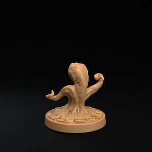 May include: A brown, fleshy, tentacled creature with a curled tentacle on top of its head. The creature is standing on a round, brown base with a textured surface.