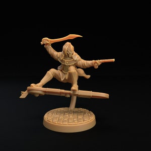 May include: A brown plastic miniature figurine of a hooded figure riding a hoverboard, holding a sword and a pistol. The figure is wearing a long coat and has a mask on their face. The hoverboard is a flat platform with a circular base.