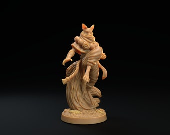 May include: A brown painted miniature figurine of a humanoid figure with a fox head, wearing a flowing robe and holding a rope in one hand.