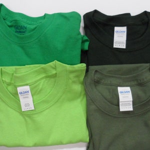 May include: Four folded Gildan brand t-shirts in green, lime green, black, and olive green.