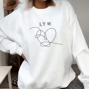 May include: White sweatshirt with a black line drawing of a heart and the text "LY 結" on the front.