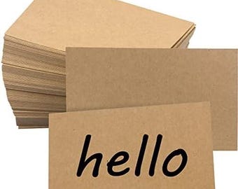 May include: A stack of kraft paper cards with the word "hello" printed in black on one card. The cards are a light brown color and appear to be blank on the back. The cards are rectangular and have a smooth surface.