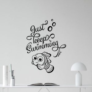 May include: Black and white wall decal featuring a cartoon fish with the text "Just keep swimming".