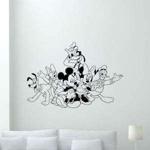 Op de afbeelding: Zwarte en witte silhouet wanddecoratie met Mickey Mouse, Minnie Mouse, Pluto, Goofy en Donald Duck. De personages zijn in een speelse groep gerangschikt, met Mickey Mouse en Minnie Mouse in het midden.