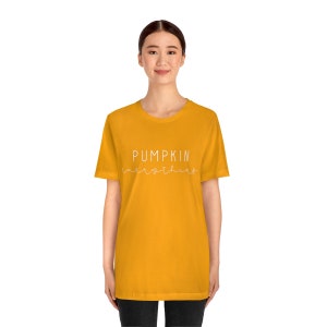 May include: A yellow t-shirt with the text "PUMPKIN everything" in white script.