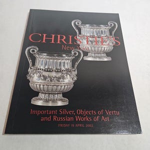 May include: A black catalog cover with the title "CHRISTIE'S New York" in red. The catalog features images of ornate silver vessels. The text reads "Important Silver, Objects of Vertu and Russian Works of Art" and "FRIDAY 19 APRIL 2002."