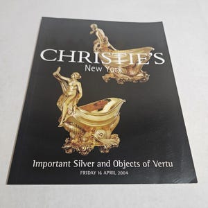 May include: A black catalog cover with the text "CHRISTIE'S New York" and "Important Silver and Objects of Vertu". The cover features gold-colored illustrations of ornate vessels with figures.