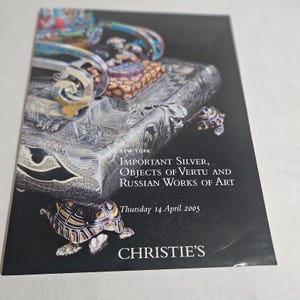 May include: A brochure for a Christie's auction featuring important silver, objects of vertu, and Russian works of art. The cover has a dark background with images of ornate silver objects and a turtle figurine. Text includes "New York" and the auction date.