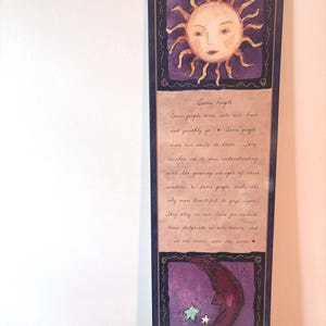 May include: A vertical wall art piece with a sun and moon design. The top section features a smiling sun with orange rays on a purple background. The bottom section has a crescent moon with two stars. Text in the middle reads "Some People".