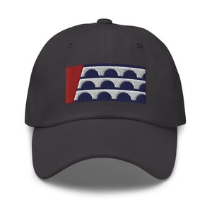 Könnte beinhalten: Eine schwarze Baseballkappe mit einer gestickten Flagge mit einem roten Streifen und weißen Bögen auf dunkelblauem Hintergrund.