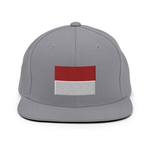 May include: A gray and red baseball cap with a red and white flag embroidered on the front.