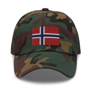 K&ouml;nnte beinhalten: Eine Baseballkappe in Tarnmuster mit einem gestickten norwegischen Flaggen-Patch auf der Vorderseite.