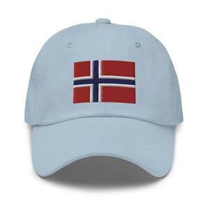 K&ouml;nnte beinhalten: Eine hellblaue Baseballkappe mit einer gestickten norwegischen Flagge auf der Vorderseite.