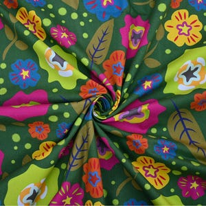May include: Green fabric with a vibrant floral pattern. The design features large flowers in shades of pink, yellow, orange, and blue, along with green leaves and polka dots. The fabric is tightly swirled, showcasing the colorful print.