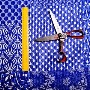 May include: A blue and white patterned fabric with a pair of silver scissors with red handles. A yellow ruler is also visible in the image.