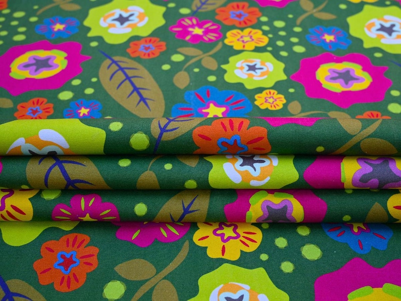 May include: Close-up of folded fabric with a repeating floral pattern. The design features large, colorful flowers in shades of pink, yellow, orange, and blue against a dark green background. The fabric also has green leaves and small green dots.