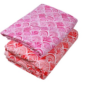 May include: Two pieces of fabric with a white background and a pink and red floral pattern. The fabric is folded in half and the pink fabric is on top of the red fabric.