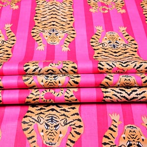 Puede incluir: Tela a rayas rosa y naranja con un patrón repetido de tigres boca abajo. Los tigres son negros y naranjas con rayas blancas.