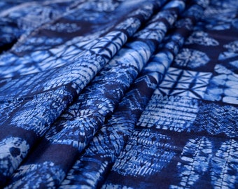 May include: Blue and white patterned fabric with a geometric design. The fabric is folded and has a soft, textured feel.