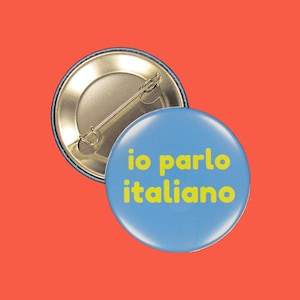 Può includere: Un bottone blu con la scritta "io parlo italiano" in lettere gialle.