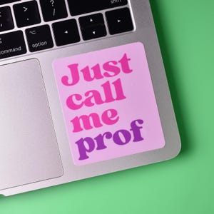 May include: A pink and purple sticker with the text "Just call me prof" on a silver laptop.