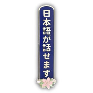 Peut inclure: &Eacute;pinglette &eacute;maill&eacute;e bleue et dor&eacute;e avec texte japonais. L'&eacute;pinglette est rectangulaire avec des bords arrondis et pr&eacute;sente les caract&egrave;res japonais en or. Un motif de fleur rose et blanche est au bas de l'&eacute;pinglette.