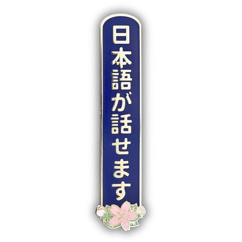 Peut inclure: &Eacute;pinglette &eacute;maill&eacute;e bleue et dor&eacute;e avec texte japonais. L'&eacute;pinglette est rectangulaire avec des bords arrondis et pr&eacute;sente les caract&egrave;res japonais en or. Un motif de fleur rose et blanche est au bas de l'&eacute;pinglette.