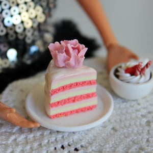 A piece of cake. Cake with a flower. Food for a doll. Dollhouse cake. Cake in 1:6 scale.