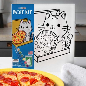 May include: A paint kit featuring a cartoon cat holding a pizza, with the text "PAINT KIT" on the box. The kit includes paintbrushes and paint pots. The image also shows a finished pizza on a yellow plate.
