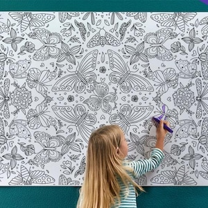May include: A large, white coloring poster featuring a repeating pattern of butterflies, flowers, and dragonflies. The poster is 6 feet long and is being colored by a person.