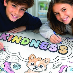 May include: A giant-sized coloring sheet with the word "KINDNESS" in colorful letters. The sheet features various outlined illustrations, including a corgi, unicorn, and ice cream cone. Two people are shown coloring the sheet with crayons and a pen.