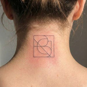 Könnte beinhalten: Ein kleines, geometrisches Tattoo auf dem Nacken einer Person. Das Tattoo ist eine schwarze Umrandung eines Quadrats mit gebogenen und geraden Linien, die ein abstraktes Design bilden. Die Haut um das Tattoo ist hell.