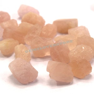 Pode incluir: Uma cole&ccedil;&atilde;o de gemas brutas rosa e brancas. As pedras s&atilde;o de v&aacute;rios tamanhos e formas e t&ecirc;m um aspeto natural e n&atilde;o polido.