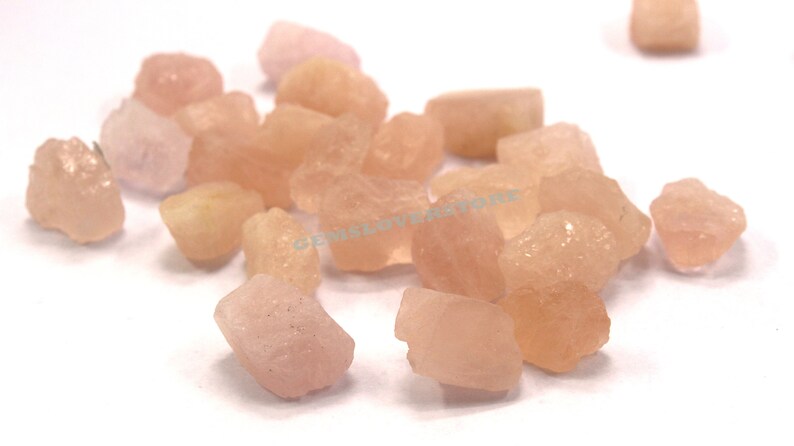 Pode incluir: Uma cole&ccedil;&atilde;o de gemas brutas rosa e brancas. As pedras s&atilde;o de v&aacute;rios tamanhos e formas e t&ecirc;m um aspeto natural e n&atilde;o polido.