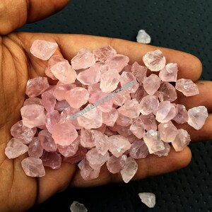 以下が含まれることがあります： ピンク色の小さなローズクォーツの結晶の山。結晶は粗く、自然な研磨されていない外観をしています。