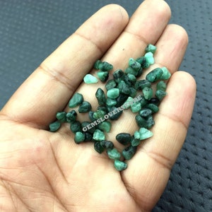 Puede incluir: Un montón de pequeñas piedras preciosas de esmeralda verde. Las piedras preciosas tienen una forma irregular y un acabado rugoso y natural.