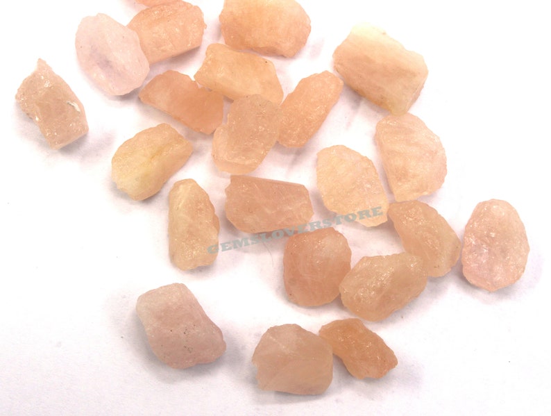 Pode incluir: Uma cole&ccedil;&atilde;o de gemas brutas rosa e laranja. As pedras s&atilde;o de v&aacute;rios tamanhos e formas, e t&ecirc;m um acabamento natural n&atilde;o polido.