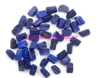 Könnte beinhalten: Eine Sammlung von etwa 30 kleinen, rauen, dunkelblauen Lapislazuli-Steinen. Die Steine sind unregelmäßig geformt und haben einen leicht metallischen Glanz.