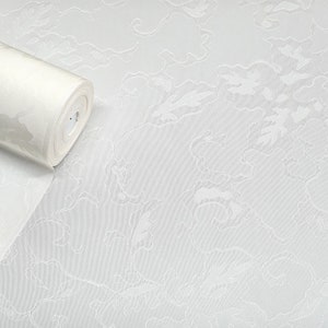 May include: A roll of white wallpaper with a subtle embossed pattern of clouds. The wallpaper has a smooth, matte finish.