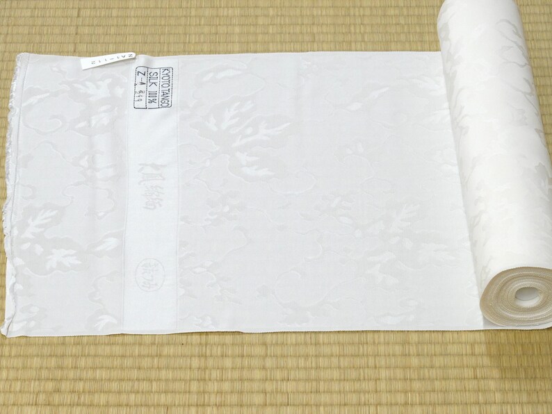 May include: A white fabric roll with a floral pattern. The fabric is labeled "Kyoto Tango Silk 100% Z-4-614".