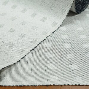 May include: White woven fabric with a subtle pattern of small, raised dots. The fabric is folded in half, showing the texture and weave.