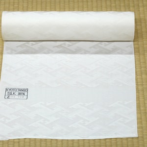 May include: A white fabric roll with a geometric pattern. The fabric is labeled "Kyoto Tango Silk 100% Z-A 732".