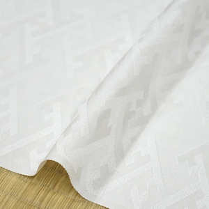 May include: White fabric with a subtle geometric pattern. The fabric is folded in half and has a smooth, silky texture.