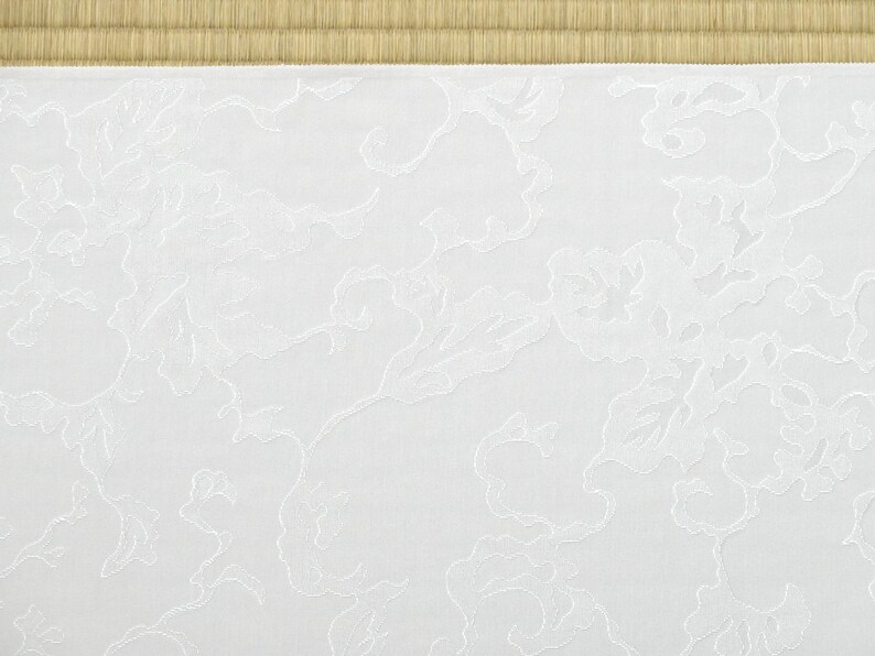 May include: White fabric with a subtle embossed pattern of swirling clouds. The fabric has a smooth, slightly textured surface.