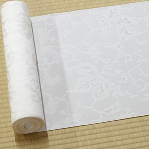 May include: A white roll of wallpaper with a floral pattern. The wallpaper has a subtle embossed texture.