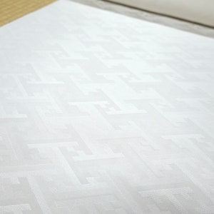 May include: White fabric with a subtle geometric pattern. The fabric has a smooth, silky texture.