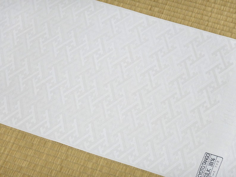 May include: White fabric with a subtle embossed geometric pattern. The fabric is labeled "Kyoto Tango Silk 100%".
