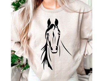May include: A beige sweatshirt with a black silhouette of a horse's head on the front.