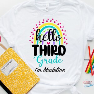 May include: White t-shirt with a rainbow design and the text "hello third grade I'm Madeline".